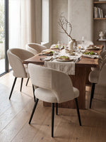 Chaise de cuisine Kamilia TOCO Meubles beige avec dossier arrondi et pieds noirs dans une salle à manger moderne