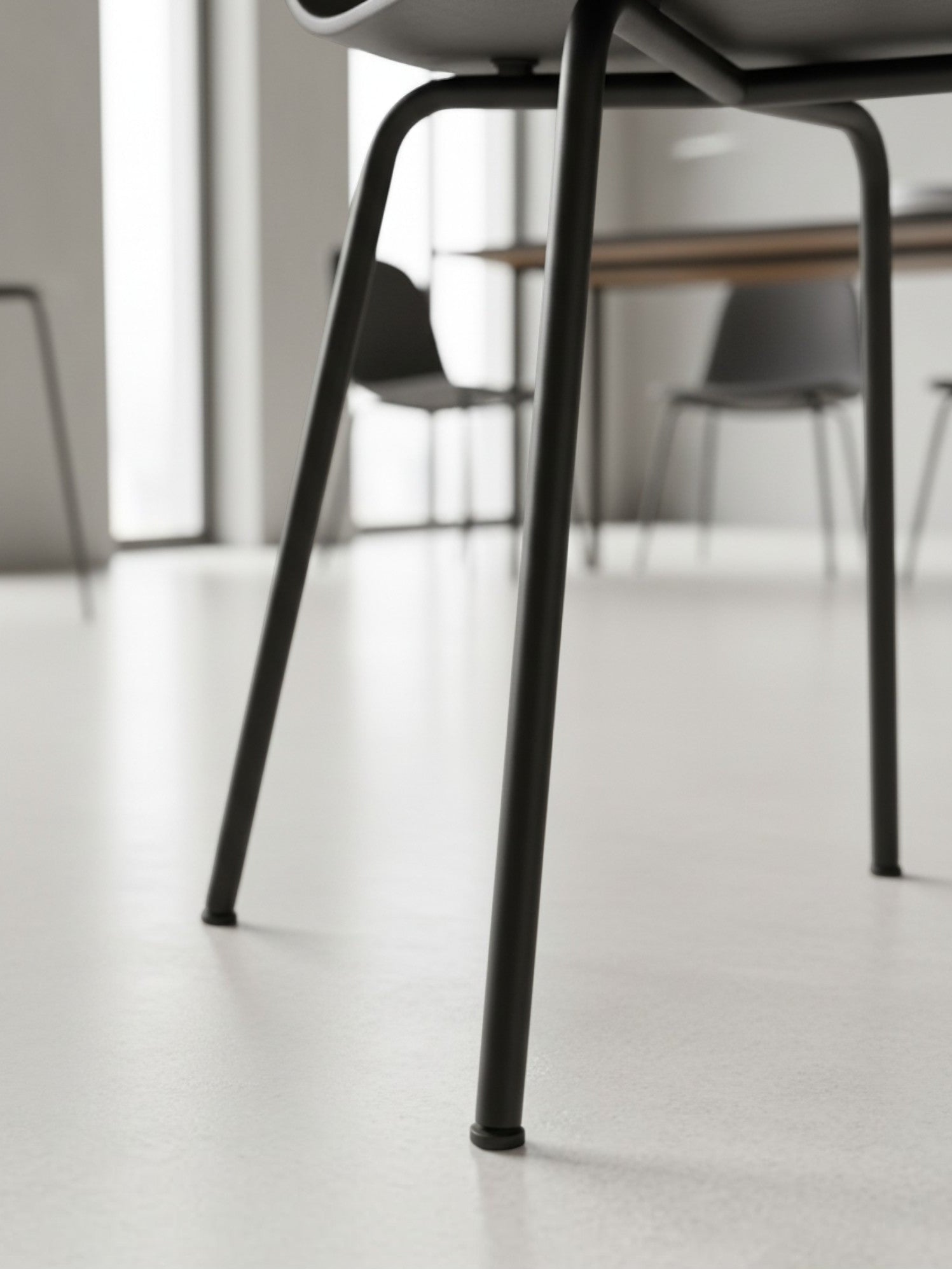 Gros plan sur les pieds en métal noir de la chaise de salle à manger Knox de TOCO Meubles dans un intérieur moderne