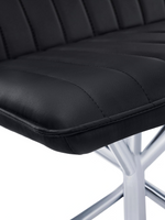 Gros plan sur le siège en similicuir noir capitonné de la chaise Marika de TOCO Meubles avec base en métal chromé