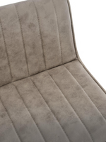 Gros plan sur le revêtement taupe capitonné à canaux verticaux de la chaise Marika de TOCO Meubles