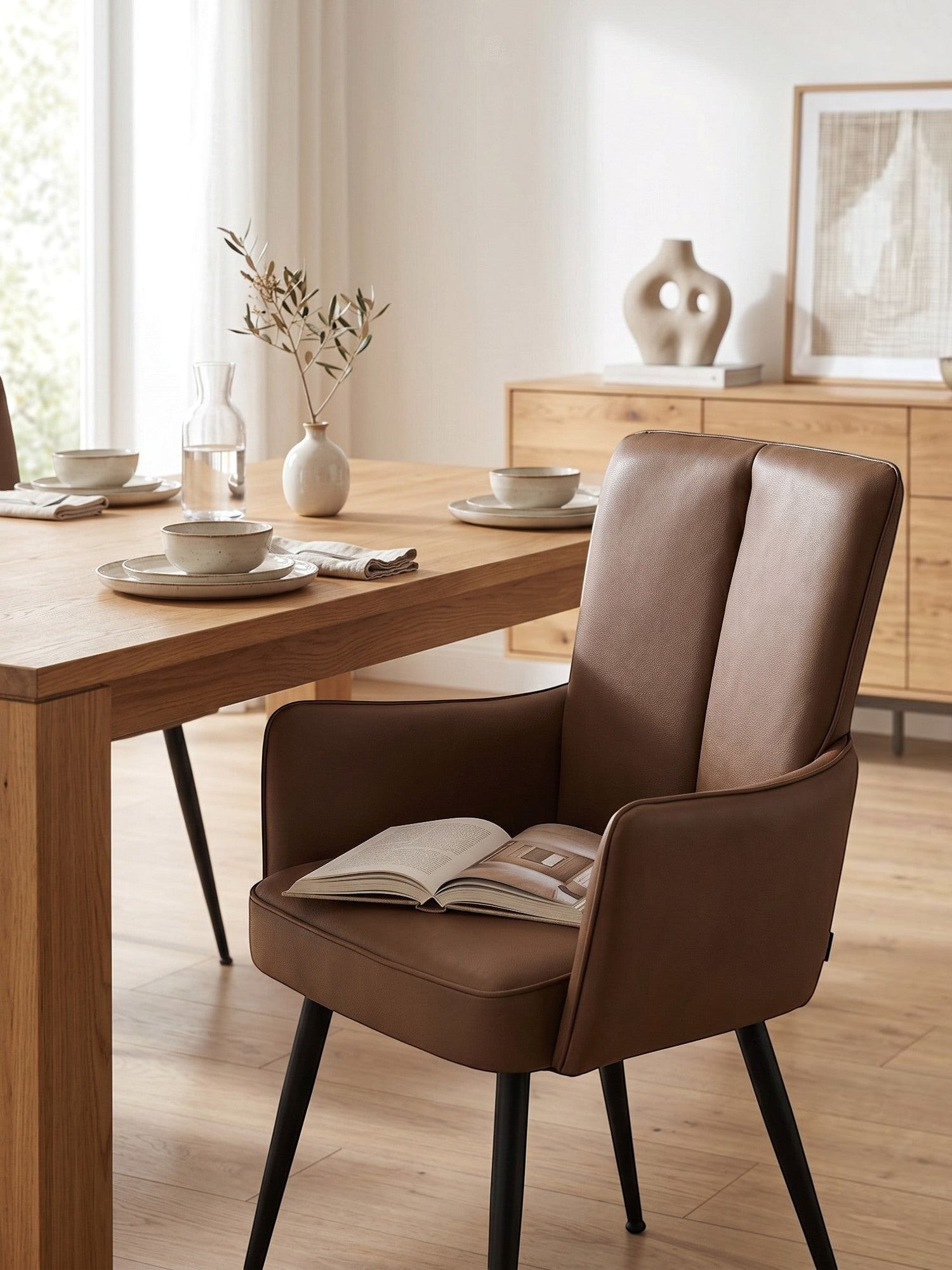 Chaise de salle à manger Milo par TOCO Meubles en similicuir marron avec pieds noirs dans une salle à manger moderne