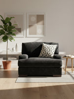 Chaise Mistral TOCO Meubles noire en tissu texturé avec coussin décoratif dans un salon lumineux
