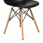 TOCO Meubles Chaise Zéphyr noire en plastique avec pieds en bois naturel et structure métallique noire.