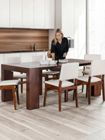Chaises Transformer Table en noyer américain par TOCO Meubles, assise et dossier blancs, pieds en bois foncé, design moderne et élégant.