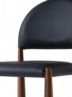 Chaise de salle à manger Ogi TOCO Meubles en similicuir noir avec dossier arrondi et pattes coniques effet noyer