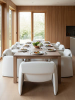 Chaise d'appoint Onda TOCO Meubles en tissu bouclette blanc autour d'une table à manger en bois dans une salle à manger