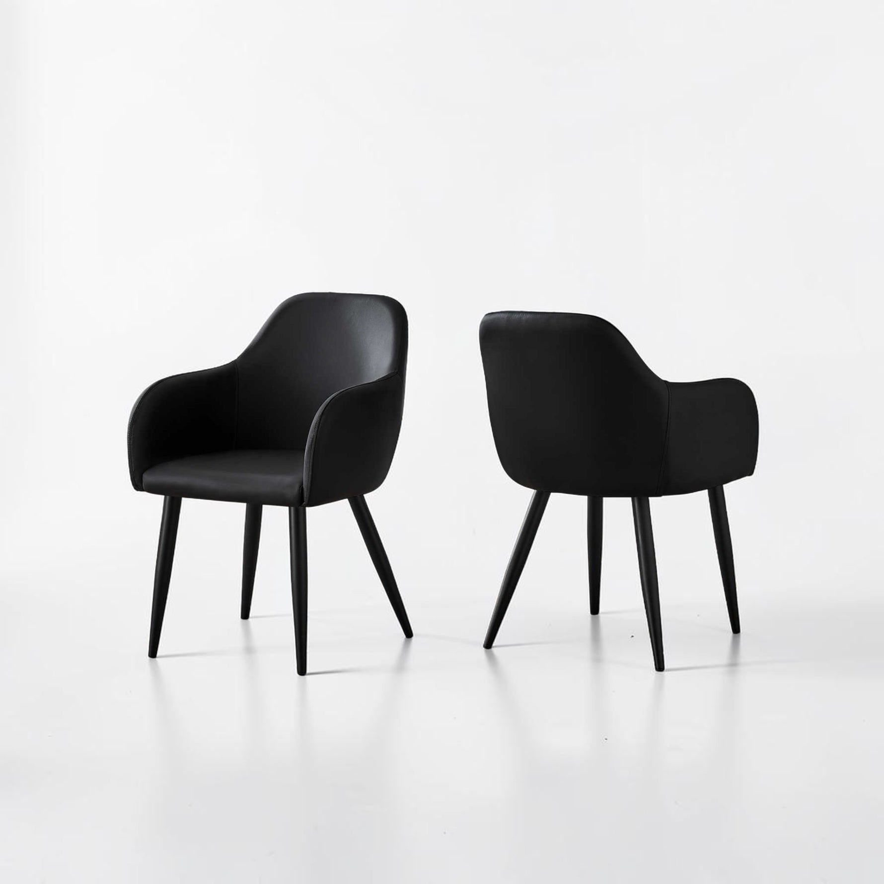 Chaise de salle à manger Parker en similicuir noir de TOCO Meubles, avec accoudoirs et pieds noirs, style contemporain.