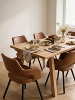 Chaises de salle à manger Rody TOCO Meubles en similicuir cognac avec pieds en métal noir autour d'une table en bois