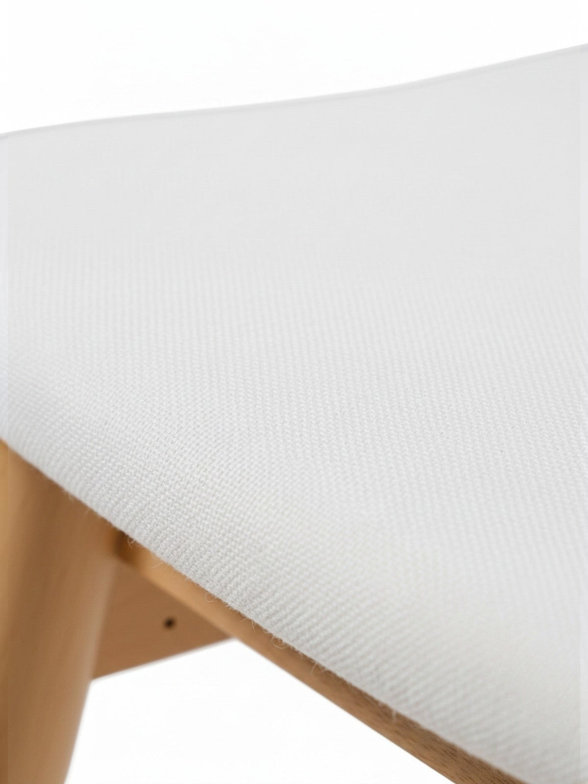 Gros plan sur l'assise en tissu blanc et la structure en chêne scandinave de la chaise TOCO Meubles Transformer