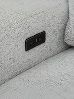 Gros plan sur le port de chargement USB intégré de la chaise Sacha en tissu gris pâle par TOCO Meubles