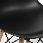 Chaise de salle à manger Zéphyr noire en plastique avec pieds en bois naturel et structure métallique noire par TOCO Meubles.