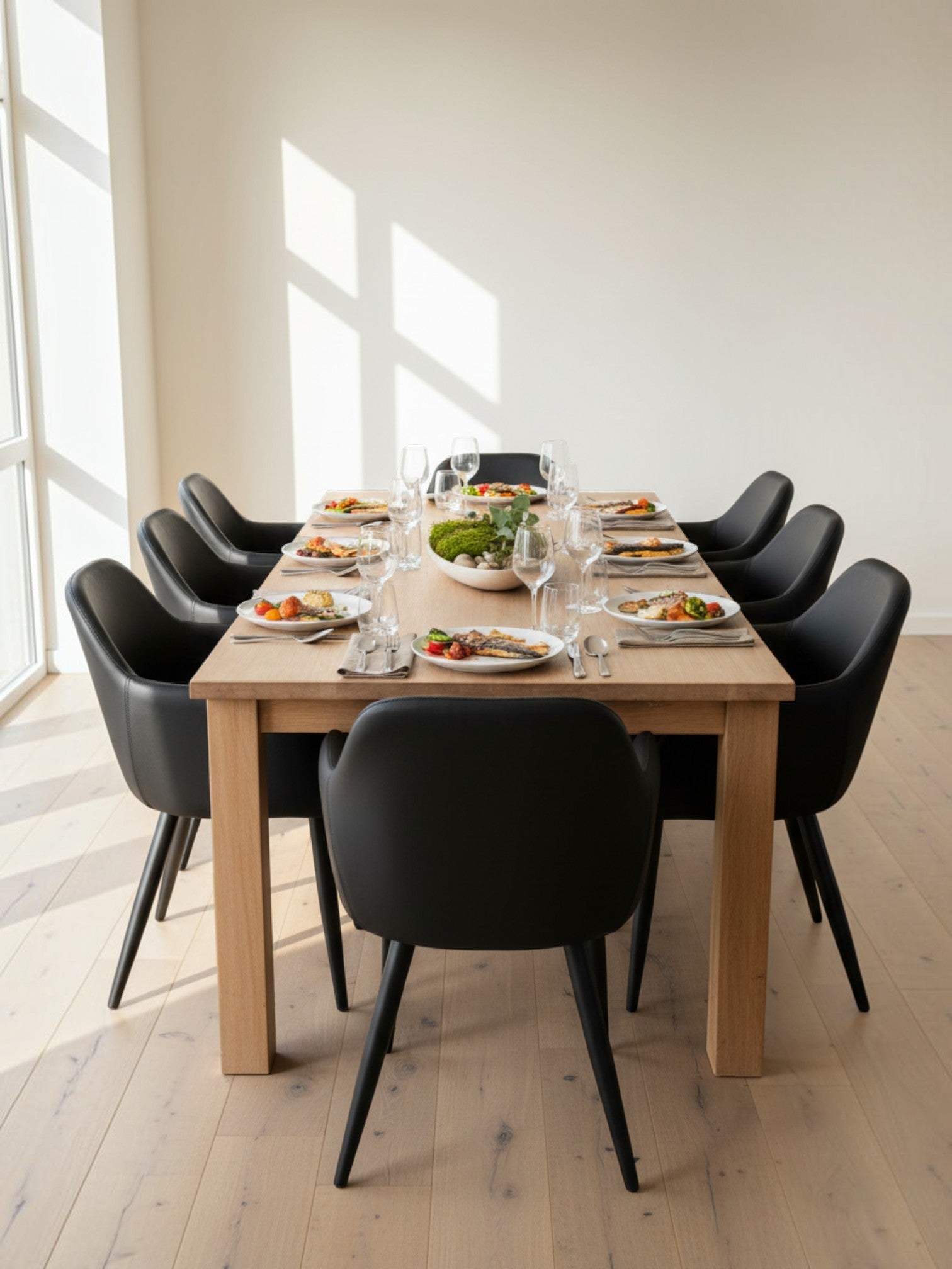 Chaise de salle à manger Parker TOCO Meubles en similicuir noir avec pieds en métal autour d'une table en bois clair