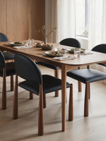 Chaise de salle à manger Ogi par TOCO Meubles en similicuir noir avec pattes en bois style noyer autour d'une table