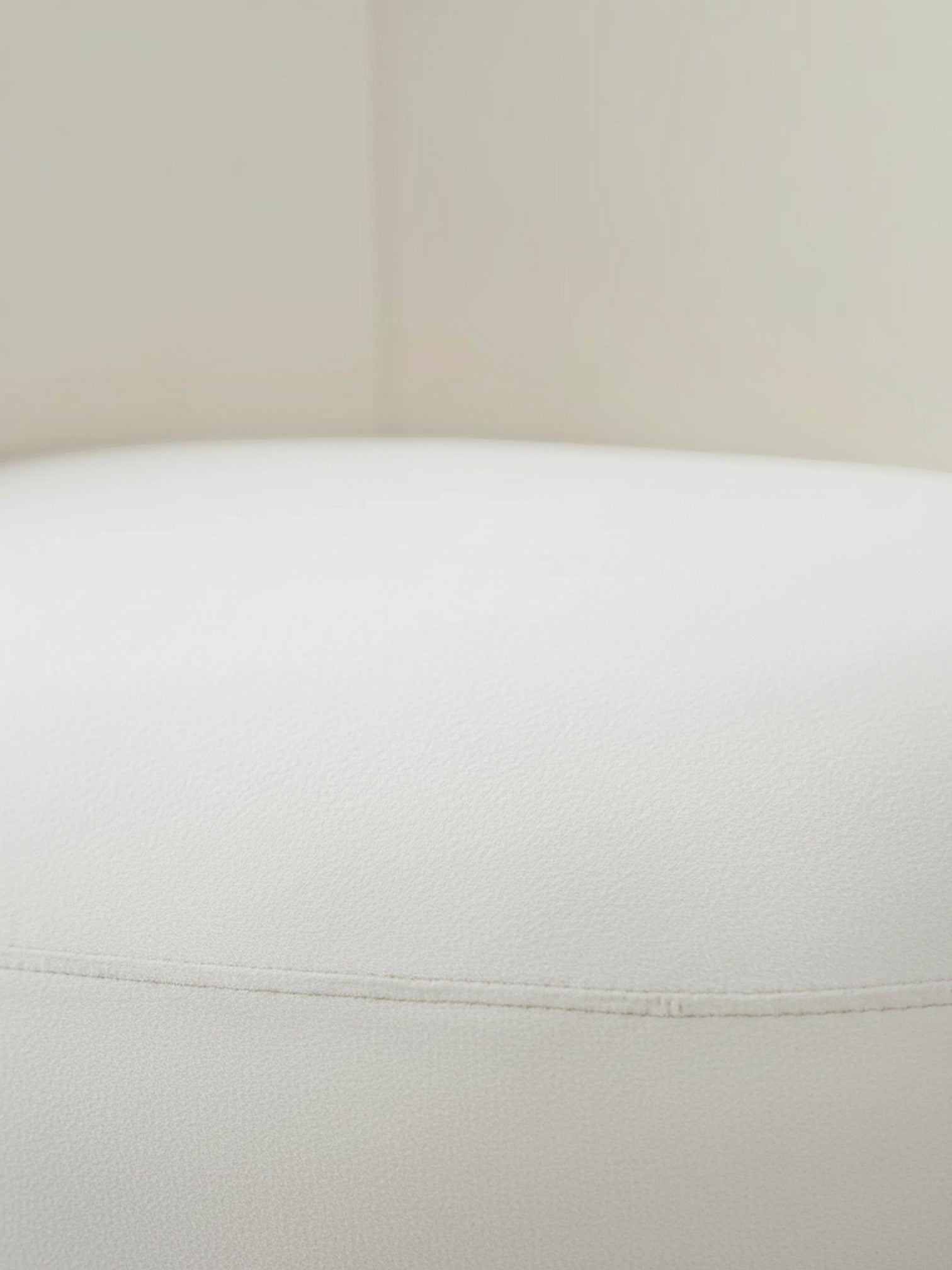Gros plan sur le revêtement en velours blanc crème de la chaise d'appoint Swayn de TOCO Meubles