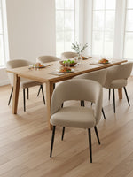 Chaise de salle à manger TOCO Meubles Valmont beige avec dossier incurvé et pieds noirs autour d'une table en bois