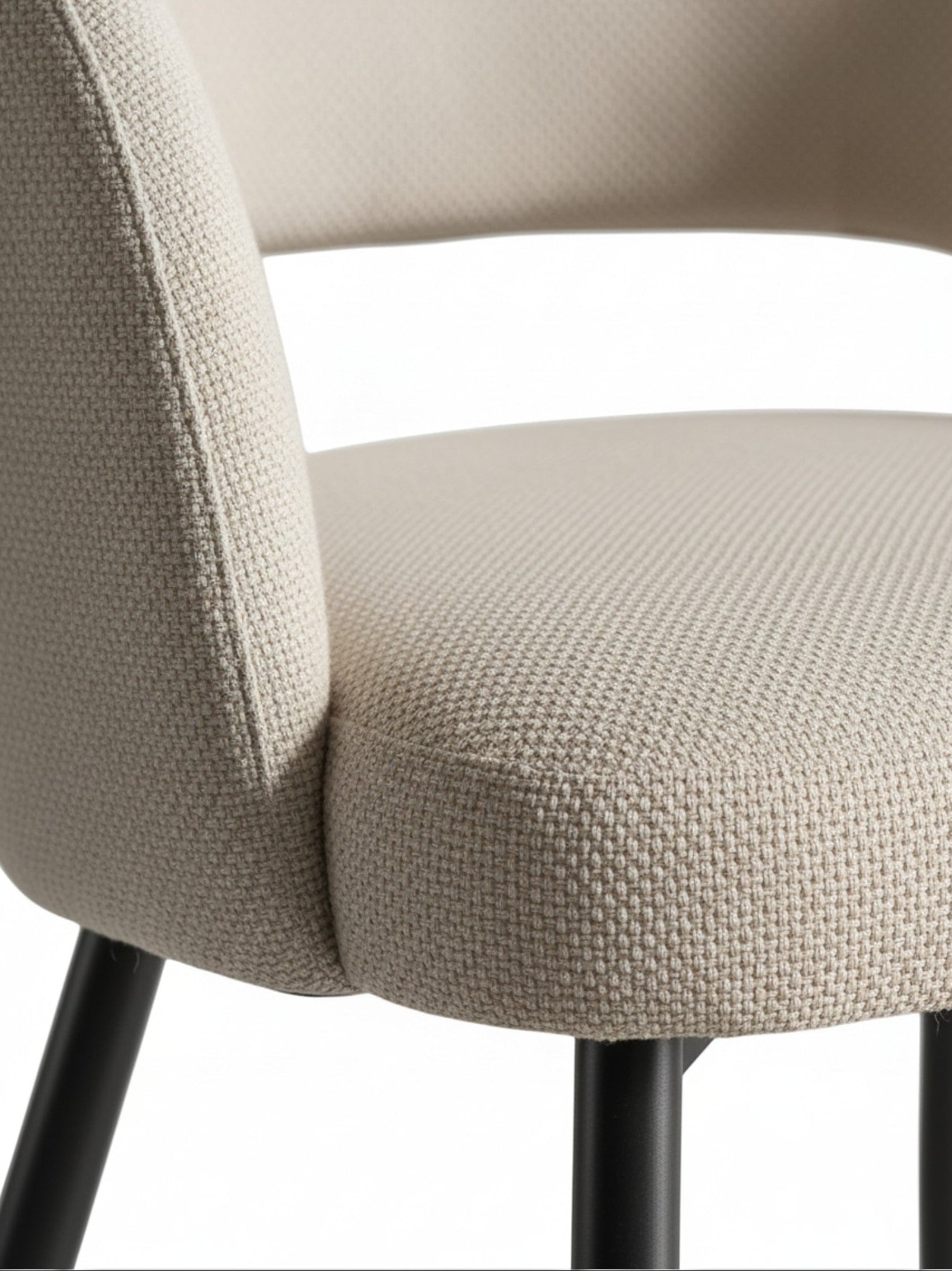 Gros plan sur l'assise texturée beige et le dossier incurvé de la chaise de salle à manger Valmont par TOCO Meubles