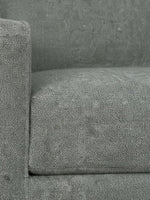 Gros plan sur le revêtement en tissu gris texturé de la chaise Zela de TOCO Meubles