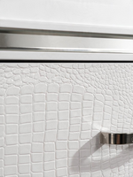 Gros plan sur la texture blanche imitation alligator et la poignée chromée de la commode TOCO Meubles Aurore