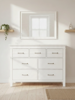 Commode double blanche Rosalie de TOCO Meubles avec sept tiroirs et poignées en chrome poli sous un miroir assorti