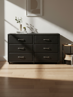 Commode double Léon TOCO Meubles en similicuir noir avec six tiroirs et poignées argentées dans une chambre moderne