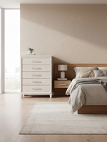 Commode haute Ariane de TOCO Meubles, blanche avec cinq tiroirs à panneaux embossés et poignées chromées dans une chambre
