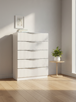 Commode haute TOCO Meubles Céleste blanc perle avec cinq tiroirs texturés et poignées argentées dans une chambre