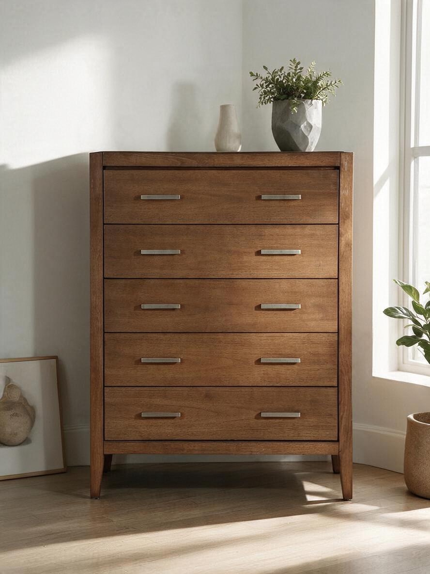 Commode haute Antoine de TOCO Meubles en bois brun clair brossé avec cinq tiroirs et poignées en laiton antique.