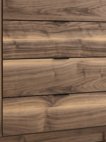 Commode haute TOCO Meubles Alma avec quatre tiroirs en bois au veinage riche et poignées noires contemporaines