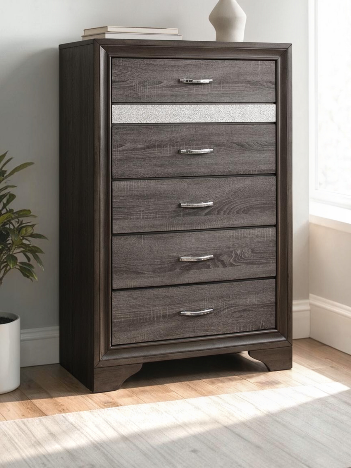 Commode haute Ines TOCO Meubles grise avec tiroirs, bande pailletée argentée et poignées chromées à faux cristaux.