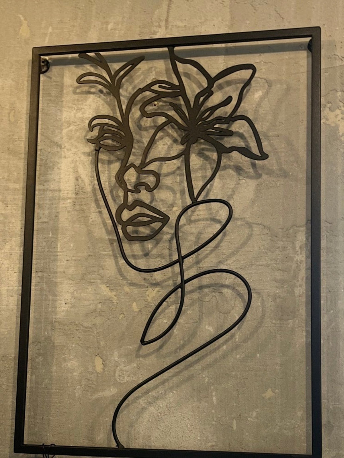 Décoration murale TOCO Meubles en métal noir représentant un portrait de femme stylisé avec une fleur