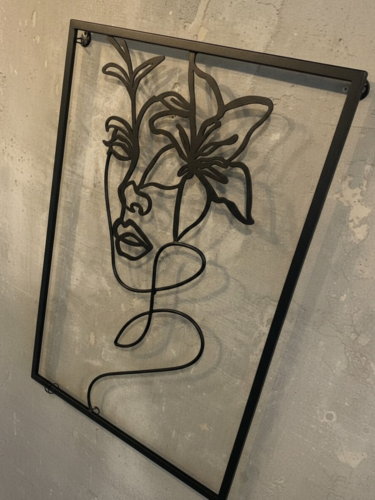 Décoration murale TOCO Meubles Heather en métal noir représentant un portrait de femme stylisé avec une fleur