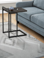 TOCO Meubles Eliott C-shaped side table with dark wood-effect top and black metal frame, next to a blue sofa.