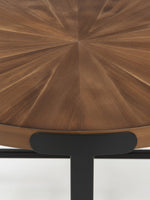 Gros plan sur le plateau rond en bois brun avec motif en rayons de soleil de l'ensemble de table Aroki par TOCO Meubles