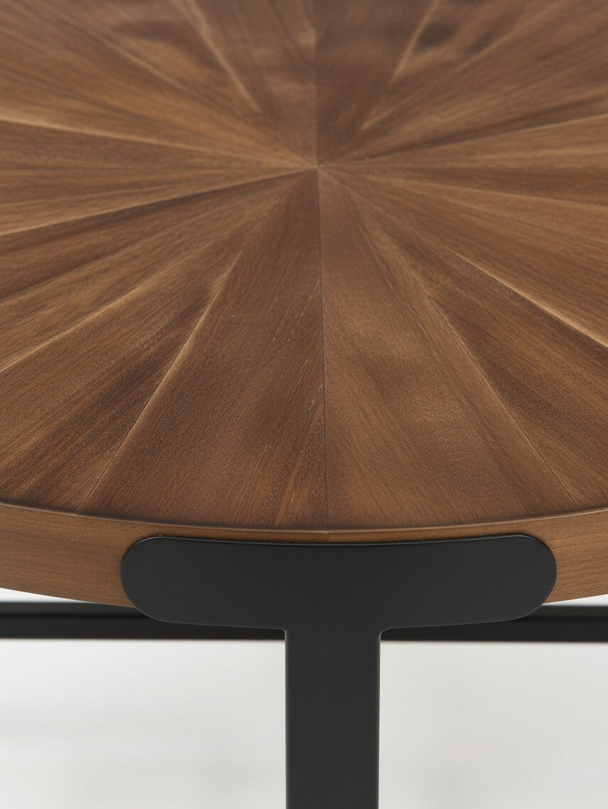 Gros plan sur le plateau rond en bois brun avec motif en rayons de soleil de l'ensemble de table Aroki par TOCO Meubles