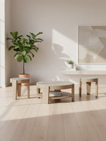 Ensemble de trois tables basses TOCO Meubles en bois clair avec plateaux ronds dans un salon minimaliste lumineux