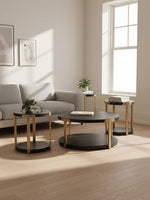Ensemble de trois tables basses TOCO Meubles Shylo avec plateaux noirs et pieds en finition laiton dans un salon