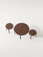 Ensemble de trois tables basses rondes en bois foncé avec pieds en métal noir de la marque TOCO Meubles