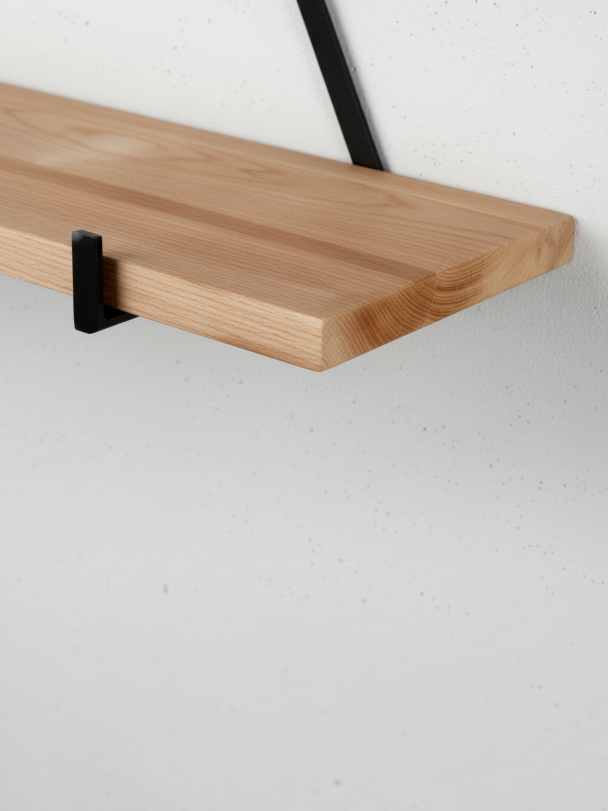 Gros plan sur une étagère suspendue TOCO Meubles en bois naturel avec support triangulaire en métal noir