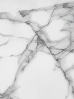Gros plan sur la texture en marbre blanc avec des veines grises de l'étagère présentoir Mona par TOCO Meubles