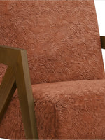 Gros plan sur le fauteuil d'appoint Caleb de TOCO Meubles en tissu bouclette rouille avec structure en bois massif.