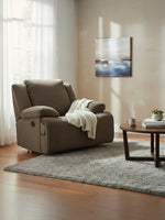 Fauteuil inclinable Enzo de TOCO Meubles en tissu brun chocolat texturé avec un plaid blanc dans un salon chaleureux.