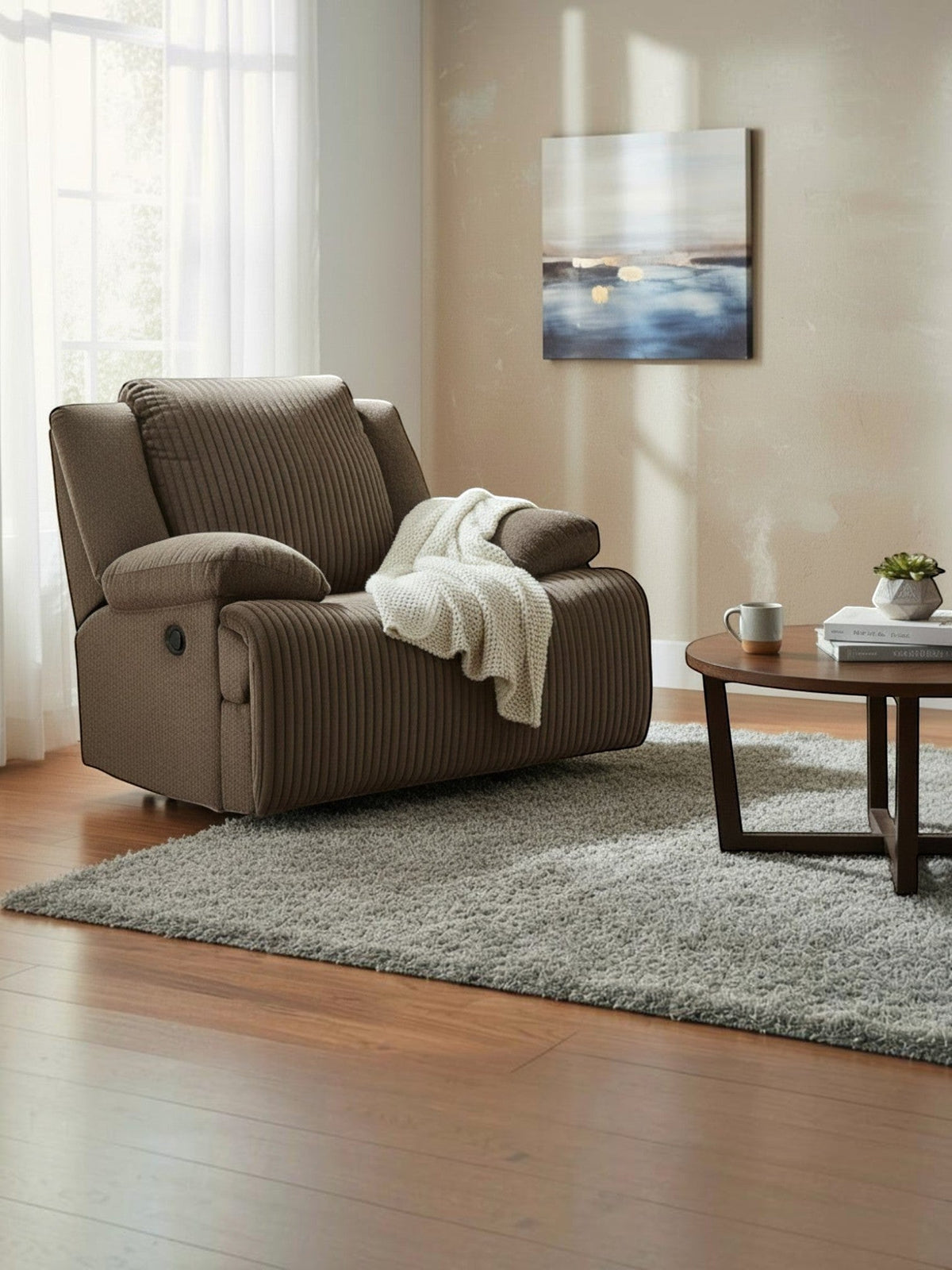 Fauteuil inclinable Enzo de TOCO Meubles en tissu brun chocolat texturé avec un plaid blanc dans un salon chaleureux.