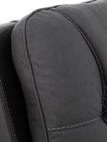 TOCO Meubles - Gros plan sur un fauteuil inclinable gris foncé avec surpiqûres contrastantes.