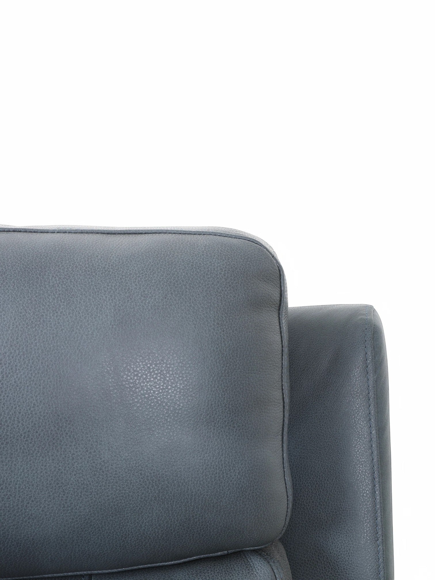 Gros plan sur le revêtement en cuir bleu gris du fauteuil inclinable Miles de TOCO Meubles, design contemporain.