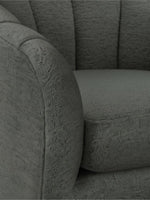 Gros plan sur le fauteuil d'appoint TOCO Meubles Noella en tissu texturé gris foncé au design arrondi et enveloppant