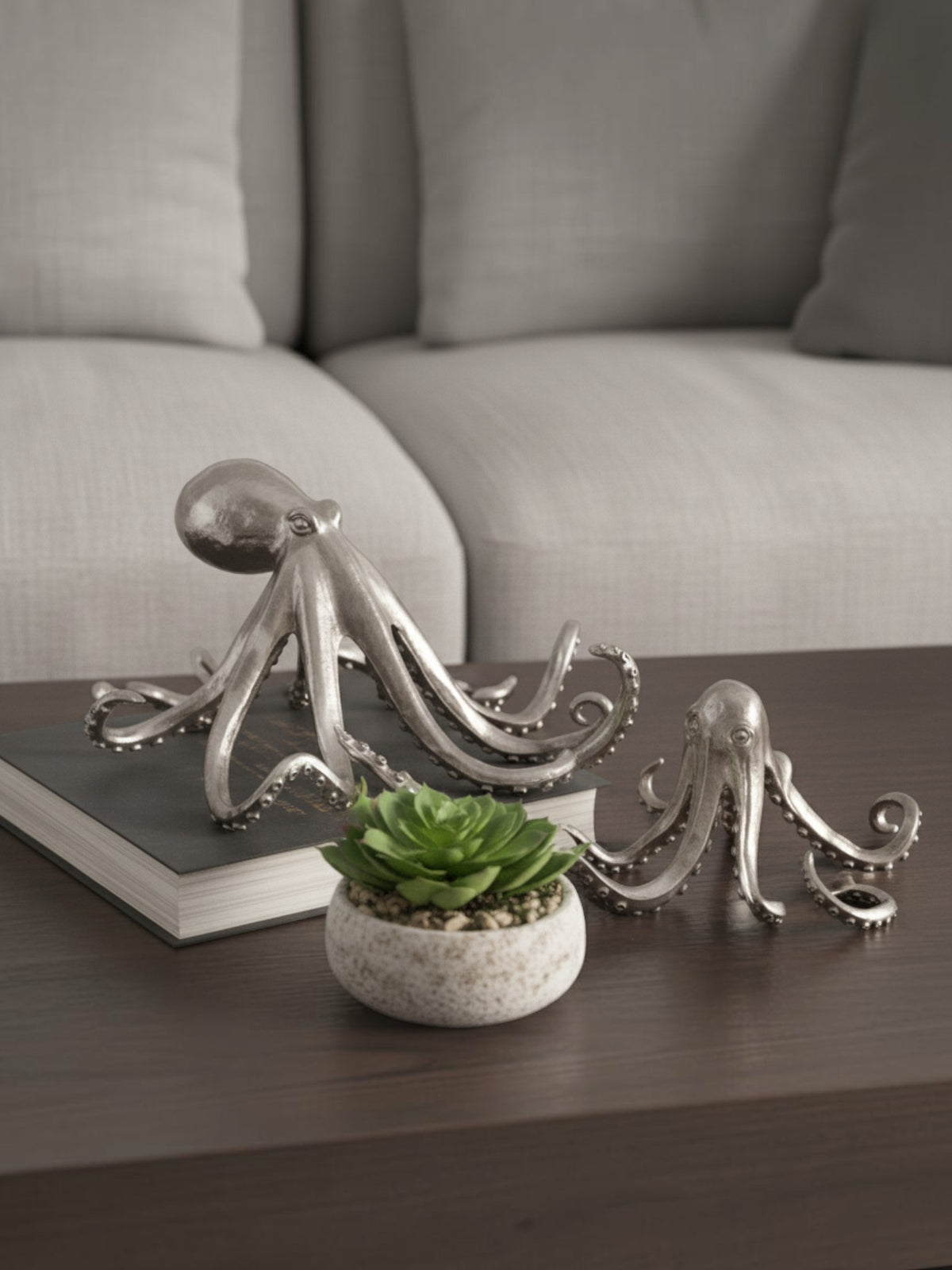 Deux figurines de poulpe TOCO Meubles en résine argentée vieillie posées sur une table basse avec une plante succulente