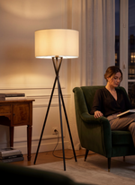 Lampadaire TOCO Meubles Ambrose en métal noir avec abat-jour en tissu blanc dans un salon chaleureux