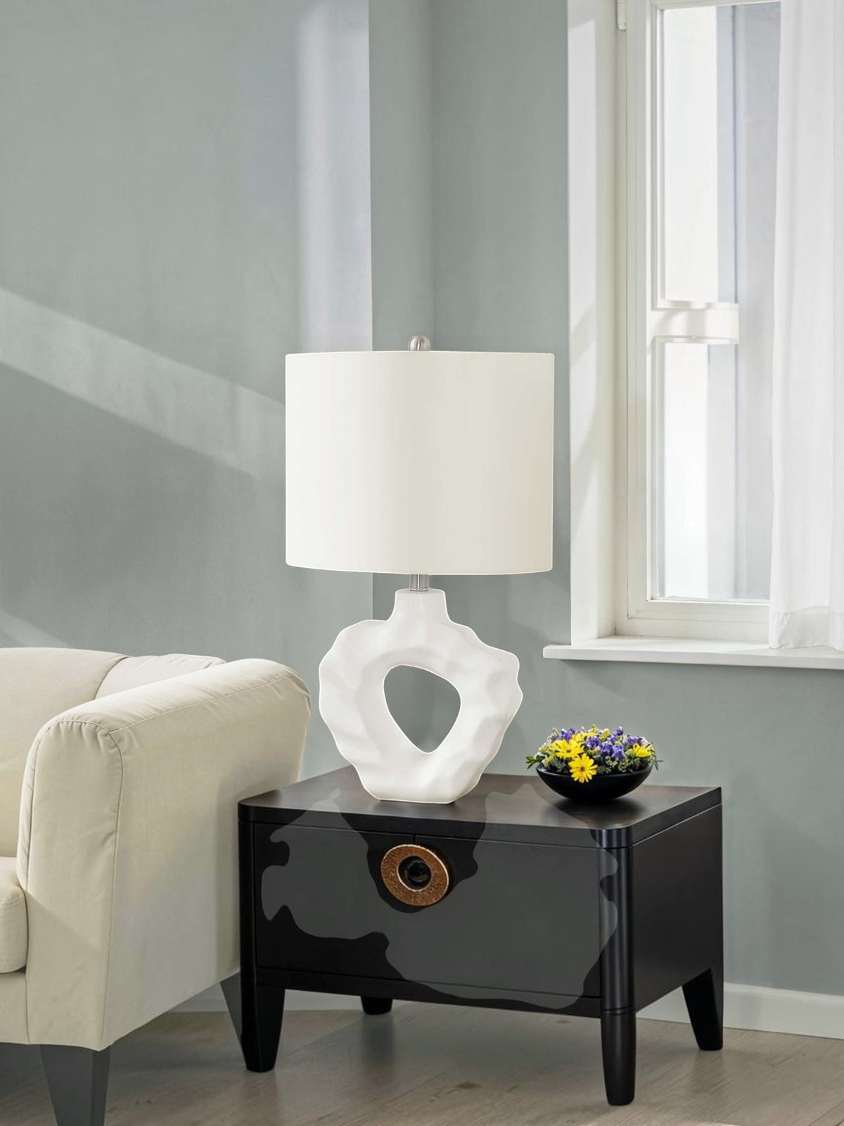 Lampe de table TOCO Meubles Belo avec base sculpturale blanche en résine et abat-jour en lin sur une table noire