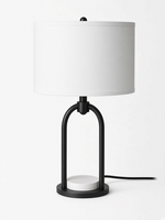 Lampe de table TOCO Meubles Sarah avec cadre arqué noir, base en marbre blanc et abat-jour cylindrique texturé blanc.