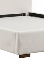 Lit plateforme TOCO Meubles Noemie en tissu bouclé beige avec pieds en bois foncé et design moderne épuré